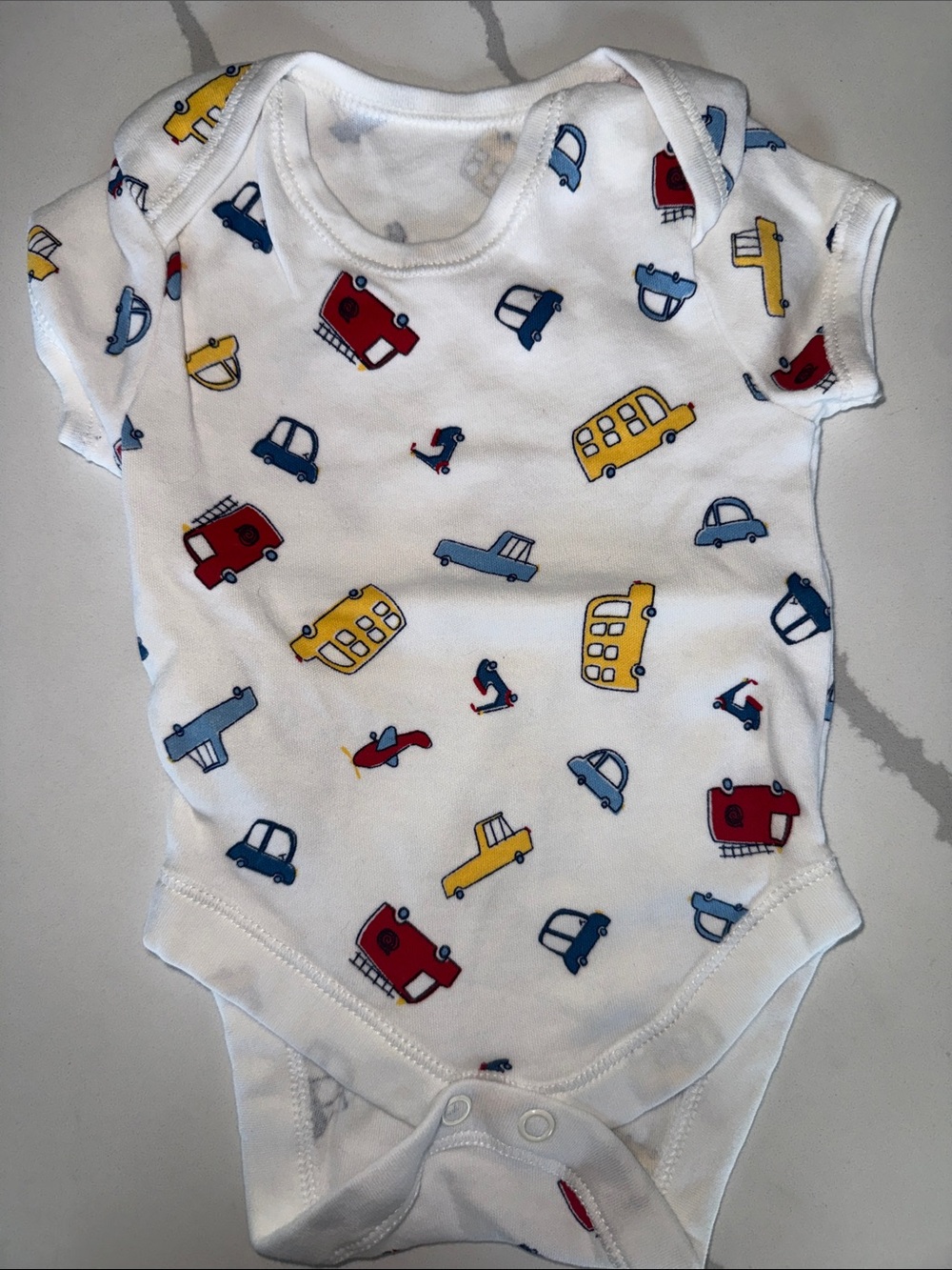 White Baby Onesie with Red, Yellow & Blue Vehicle Print